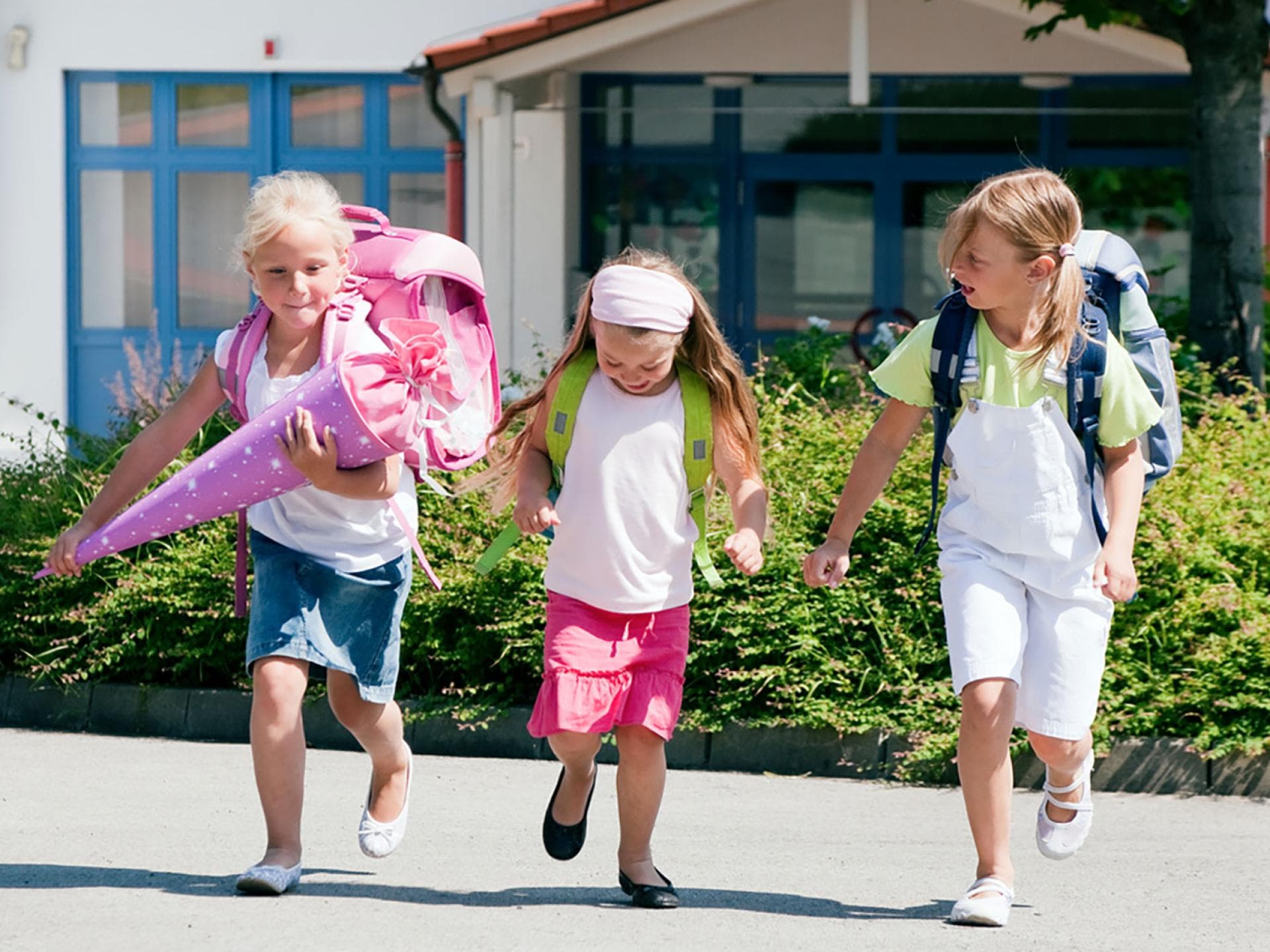 Die passenden Einschulungsgeschenke zu finden ist gar nicht so leicht. Drei Schulkinder mit einer Schultüte.