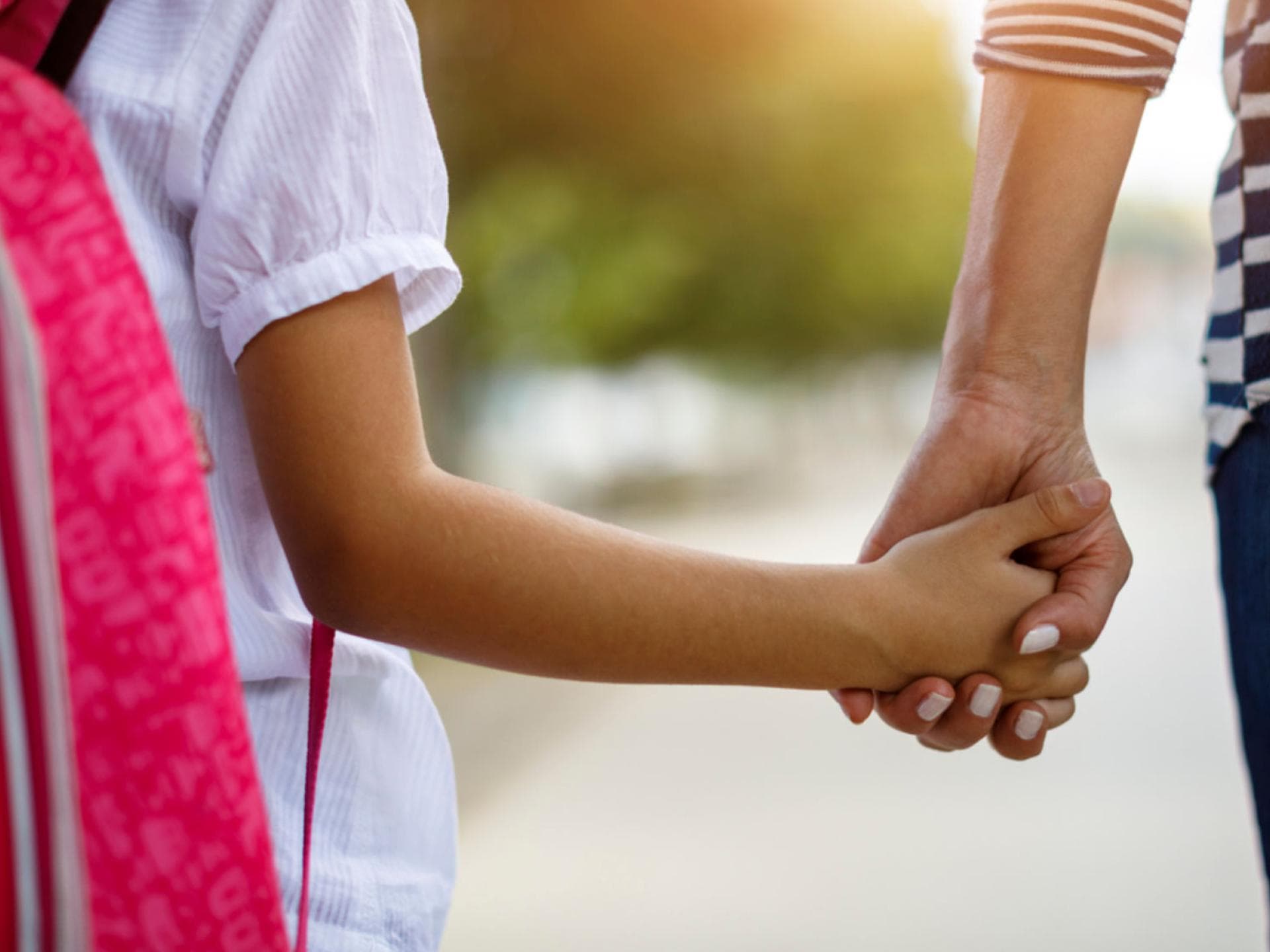 Tief durchatmen und los: Der Schulstart ist auch für Eltern aufregend! Schulkind an der Hand der Mutter.