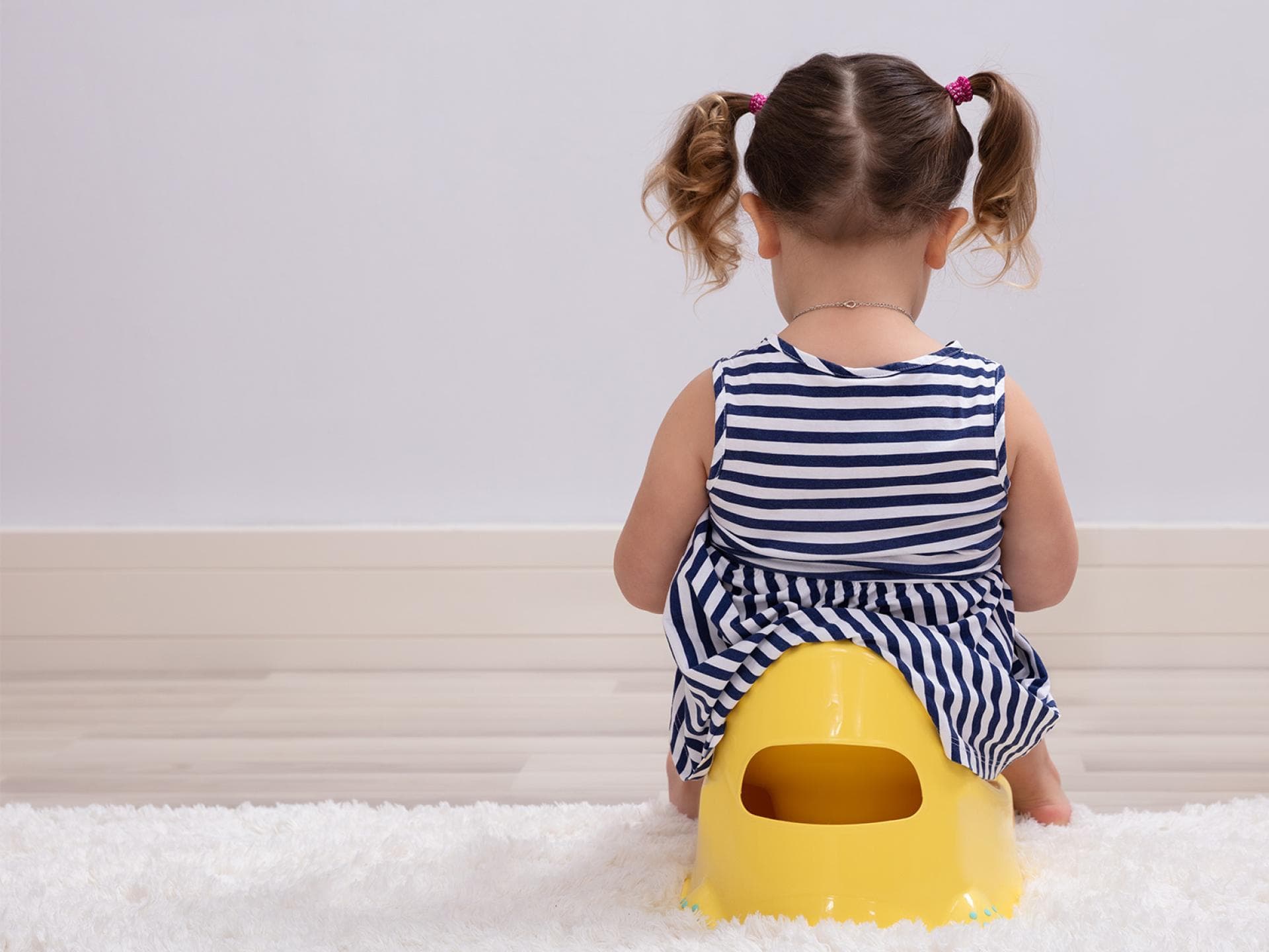 Kinder sollten nicht zum Trocken werden gedrängt werden. Mädchen sitzt auf dem Töpfchen.