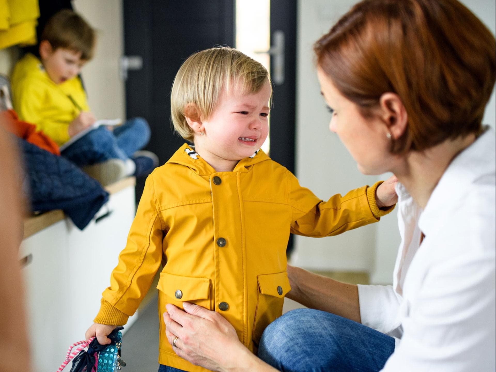 Ein Geschwisterkind kommt weinend zur Mama.