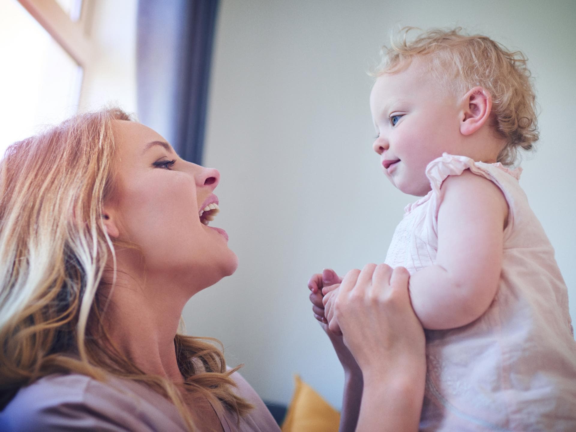 Eltern können ihre Kinder bei der Sprachentwicklung unterstützen. Mutter spricht mit ihrem Baby.