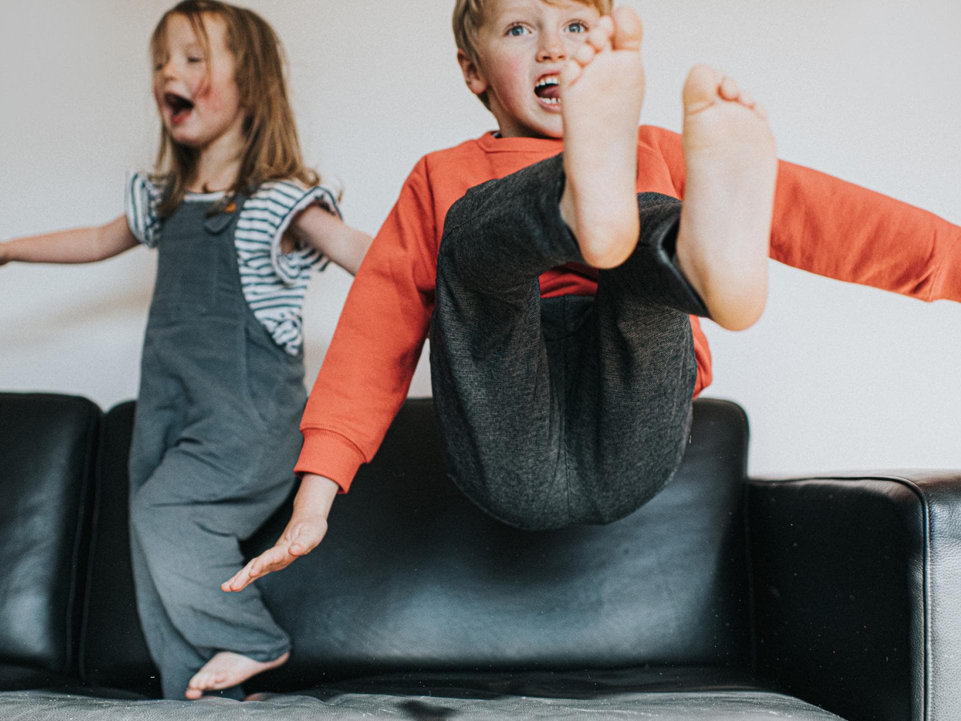 Hyperaktiv oder einfach nur gut drauf? Kinder werden heutzutage leider schnell mal mit einer Diagnose bedacht. Zwei auf dem Sofa tobende Kinder