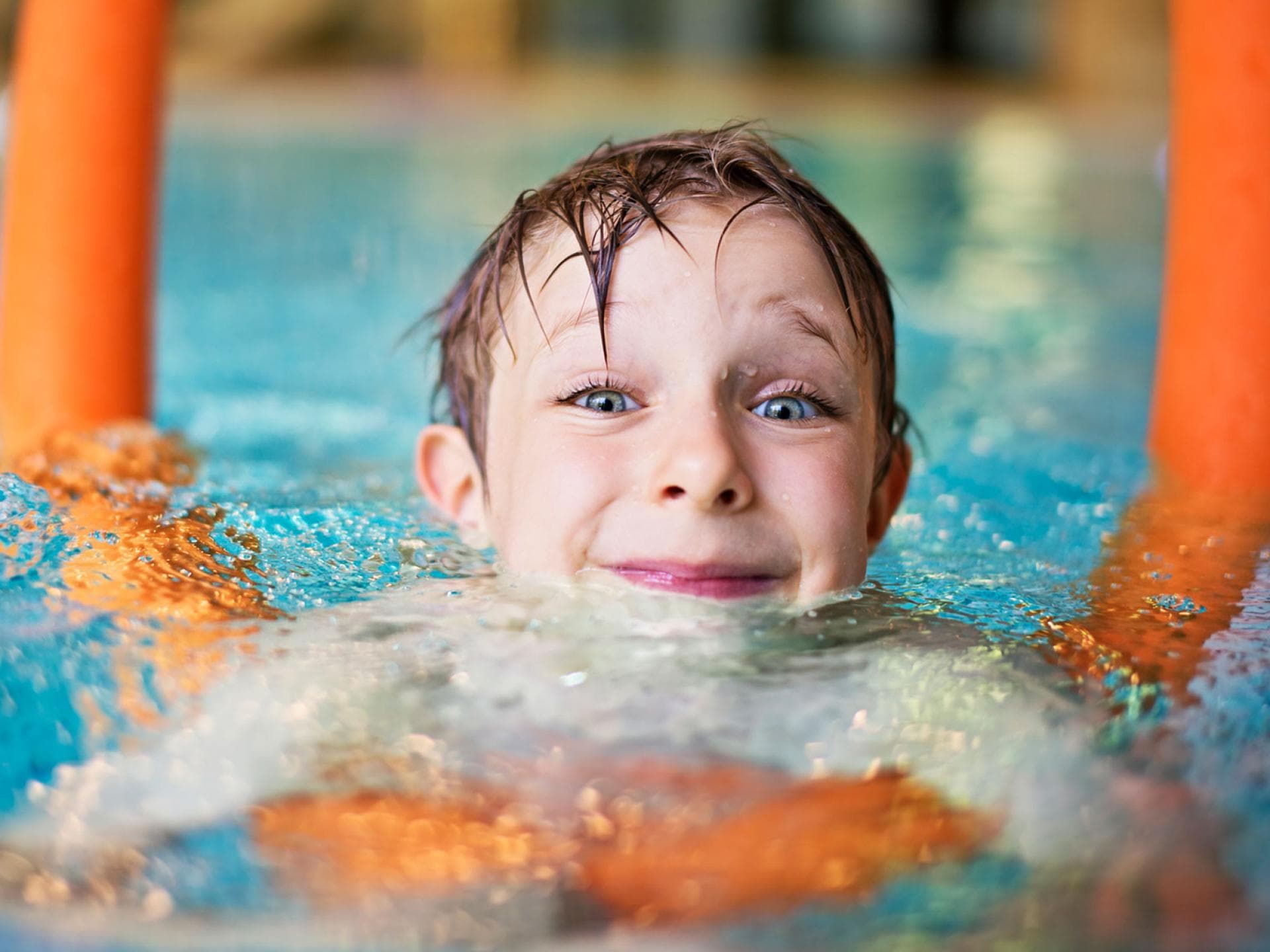 Das Wichtigste beim Schwimmenlernen: Der Spaß im Wasser! Kind mit Schwimmnudel im Wasser.