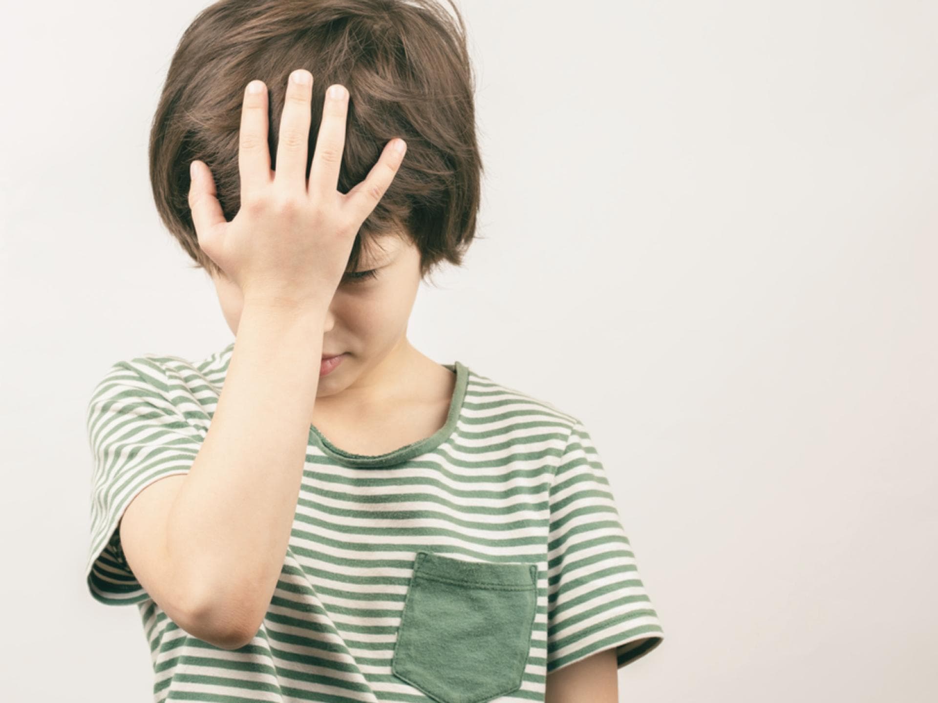 Dass sechs- und siebenjährige Kinder öfter mal etwas vergessen und ihre Sachen liegen lassen, ist nicht ungewöhnlich. Kind hält sich die Hand vor den Kopf.