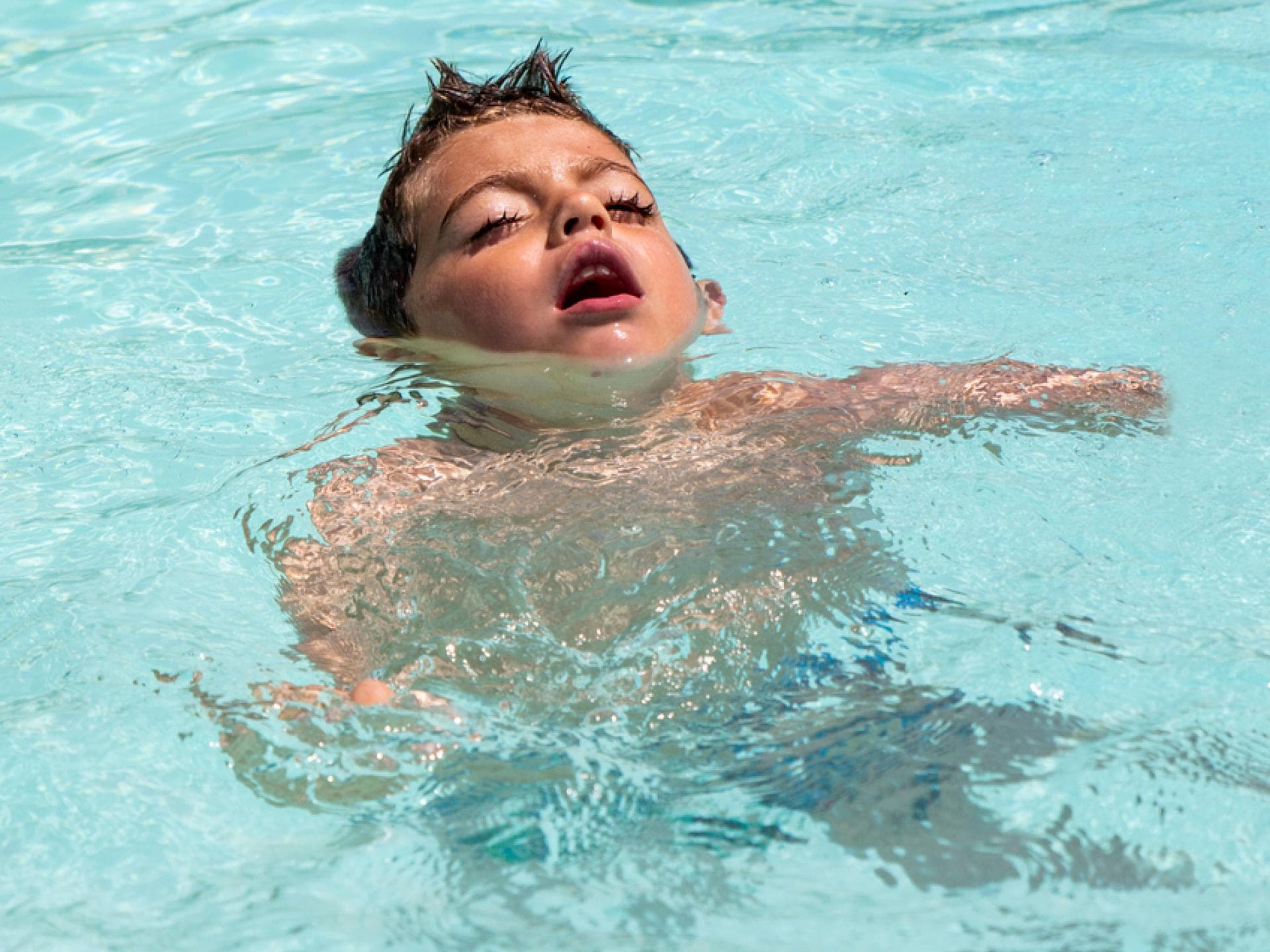 Junge mit geschlossenen Augen im Wasser.