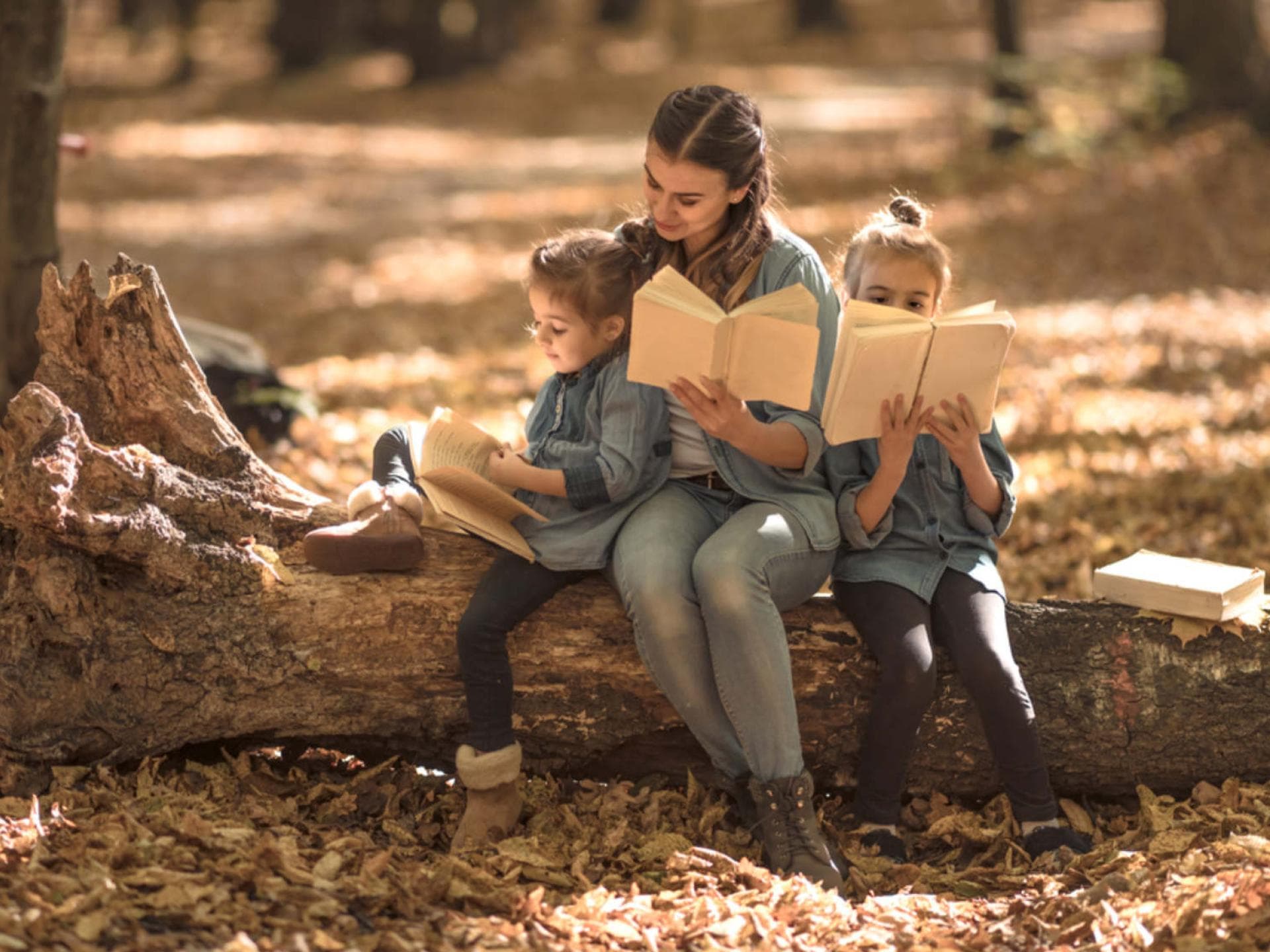Eine Mutter übt mit ihren zwei Kindern Herbstgedichte.