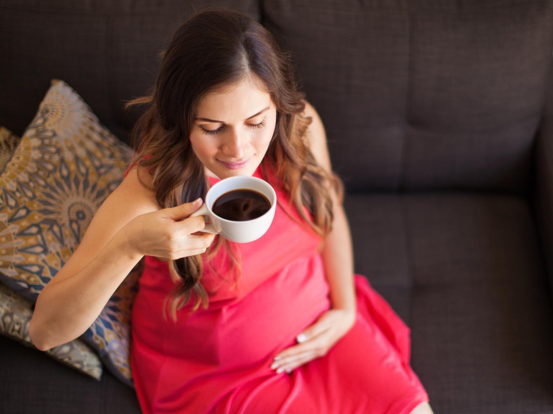 Werdende Mamas müssen zum Glück nicht ganz auf Kaffee in der Schwangerschaft verzichten. Schwangere Frau trinkt Kaffee.