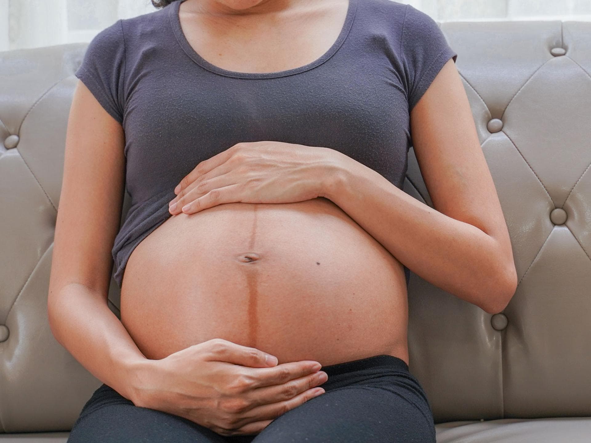 Eine schwangere Frau mit Linea Negra auf dem Babybauch. 