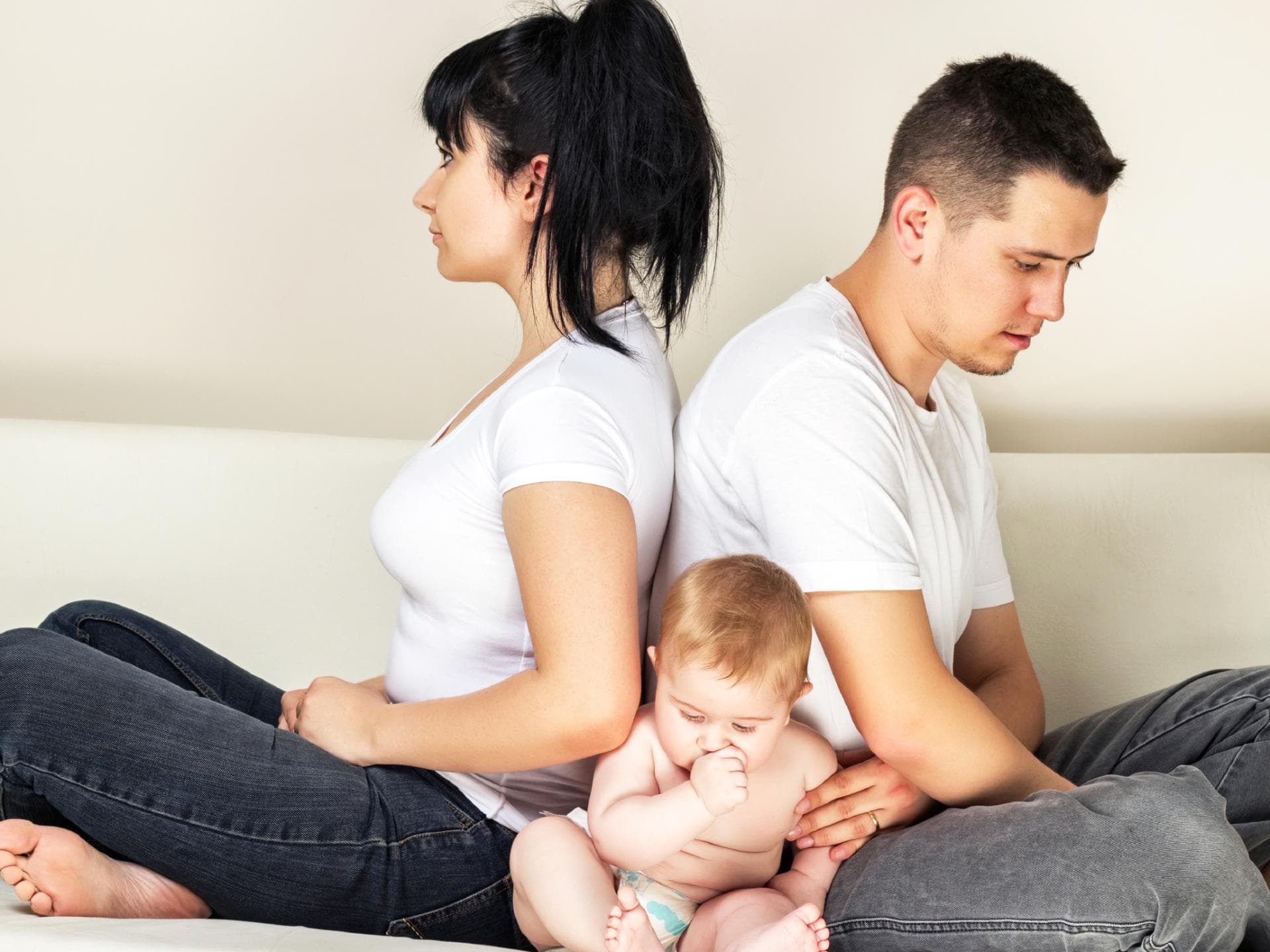 Babys sind oft eine Belastungsprobe für die Beziehung junger Eltern. Genervte Eltern mit Baby.