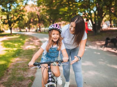 Mama bringt Tochter Fahrradfahren bei