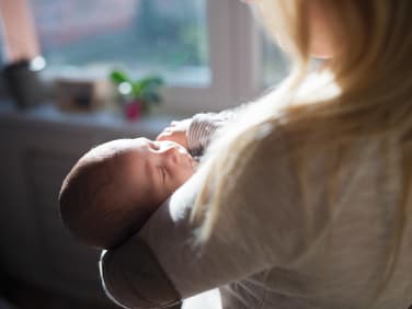 Mutter hält ihr Baby im Arm.
