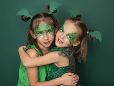 Mädchen, die als Drachen geschminkt sind.