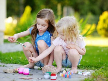Kleine Mädchen basteln mit Steinen 
