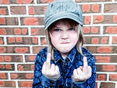 Kleines Mädchen zeigt den Mittelfinger.