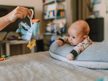 Ein Baby, das mit einem Vogel spielt