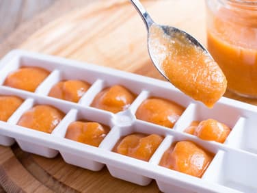 Babybrei in Eiswürfelbehälter füllen.