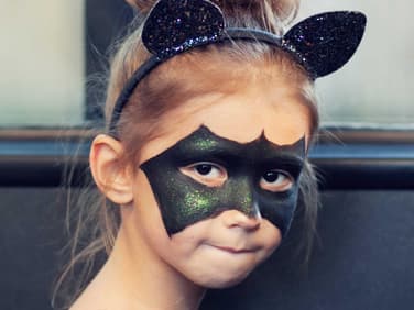 Mädchen als Fledermaus geschminkt.